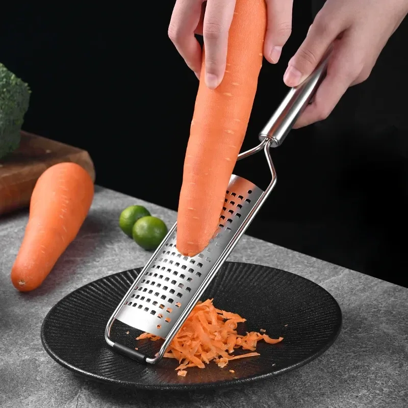 carrot grated over a plate with the stainless steel handheld grater