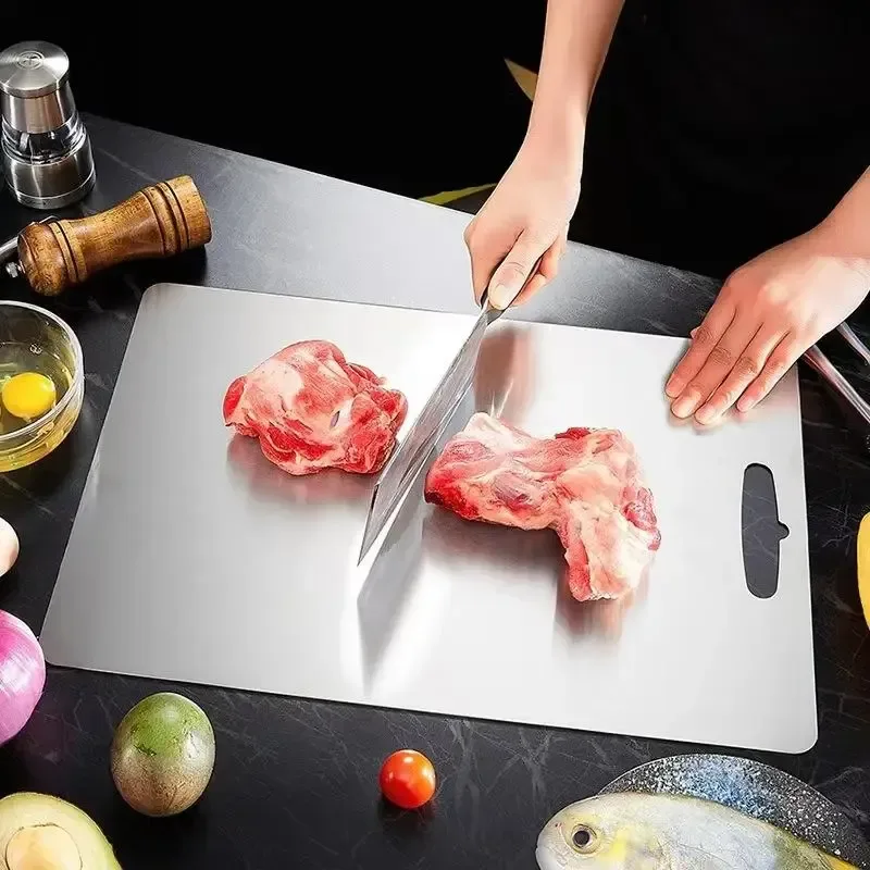 cutting raw pork on a stainless steel cutting board