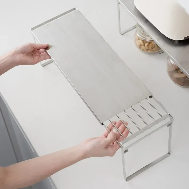 hands sliding an expandable stainless steel shelf to fit a cupboard
