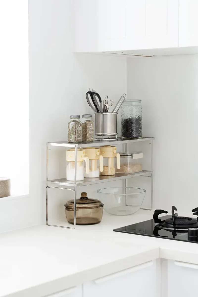 stainless steel shelf holding spices and utensils on a worktop